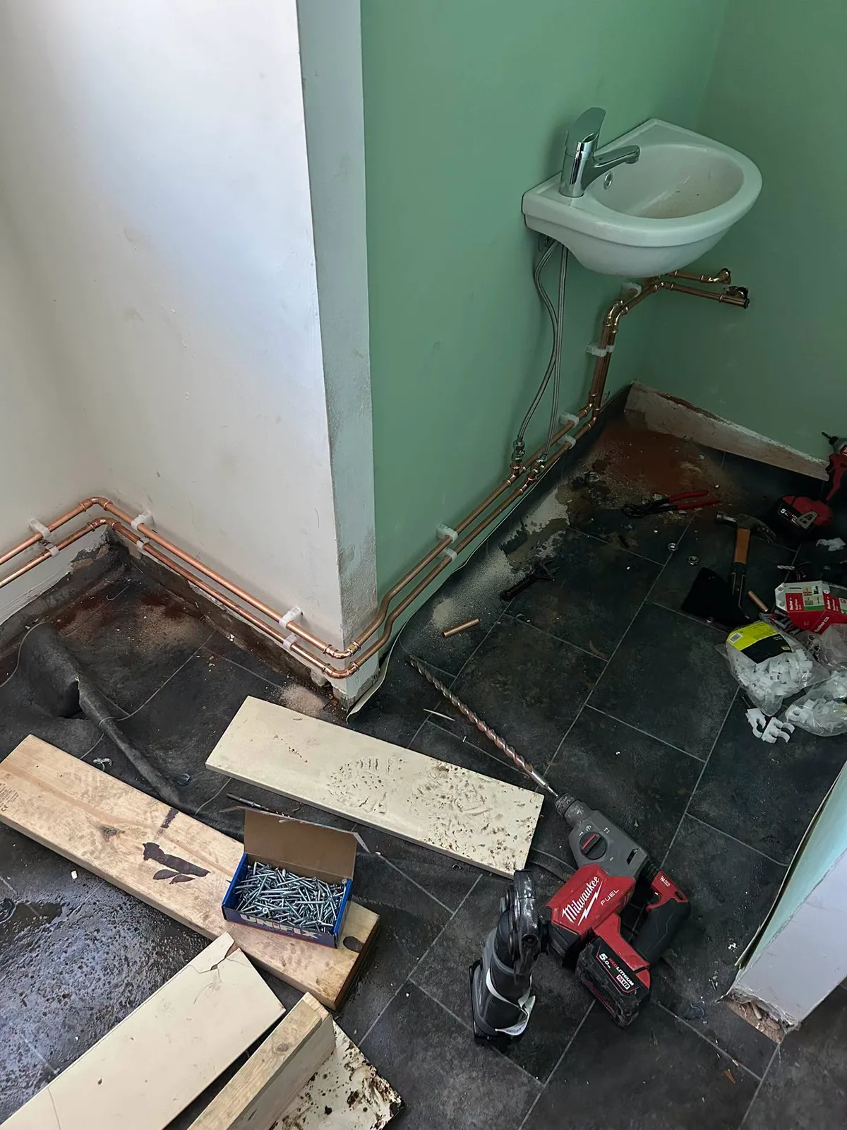 Exposed bathroom waste and supply pipework during repair