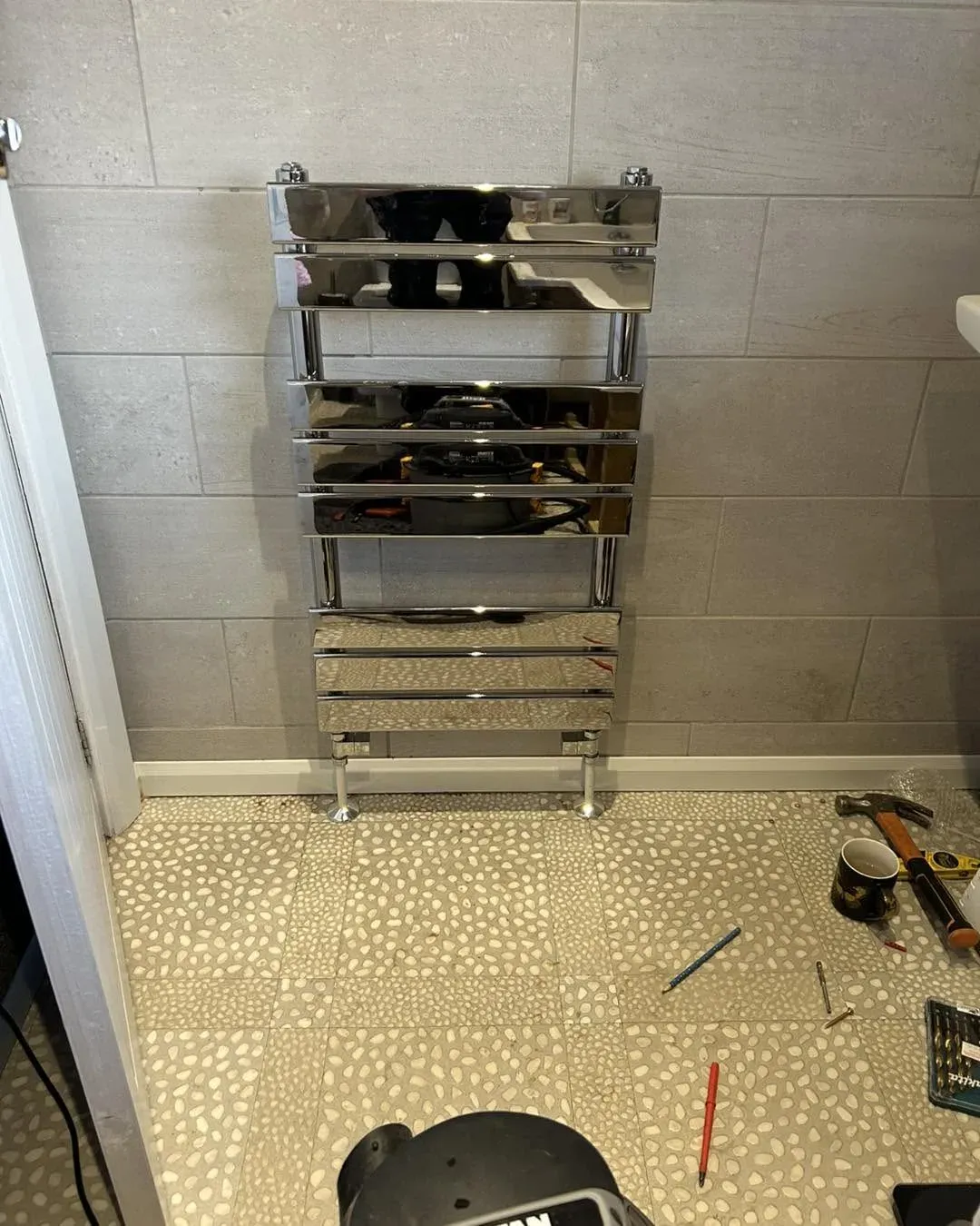 Chrome heated towel radiator installation